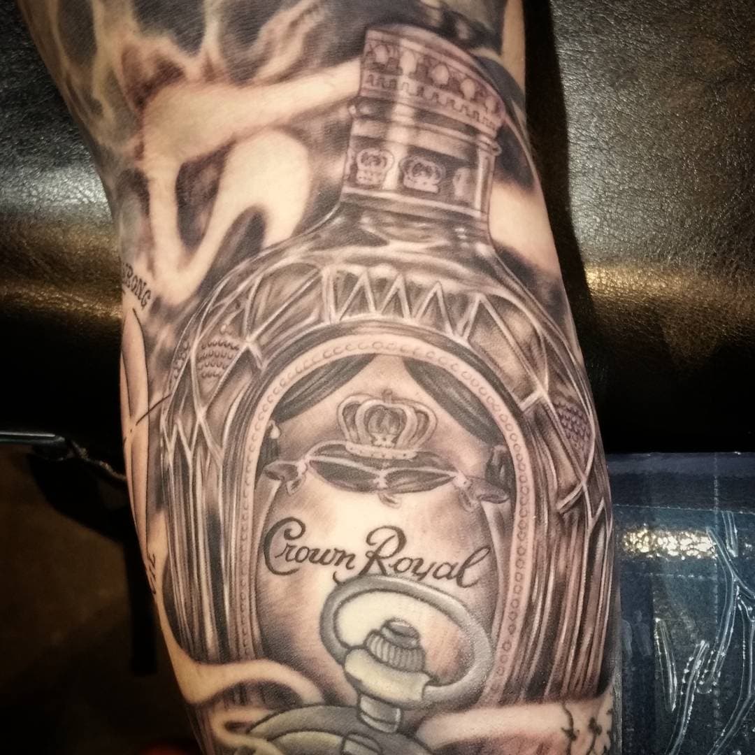 Wonky pic of this @Crownroyal gap filler from last weekends #savannahtattoofestival One more booze bottle for the collection. Love doing these. #crownroyal #whiskey #ladytattooers #darkartists #blackandgray #conventionlife #savannah #tattoo #convention #grind
