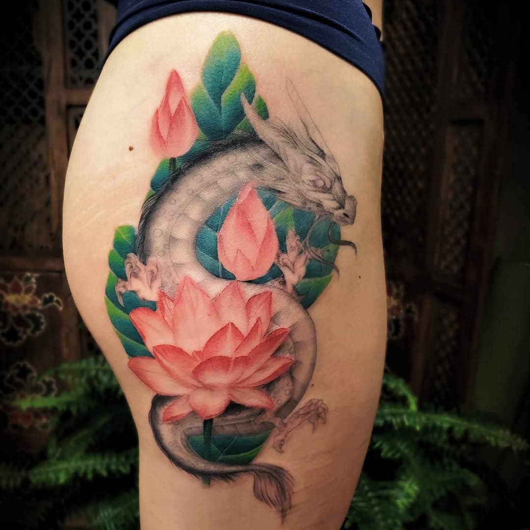 Dragon and lotus tattoo by Robia. Follow her on Instagram @robiatattoos