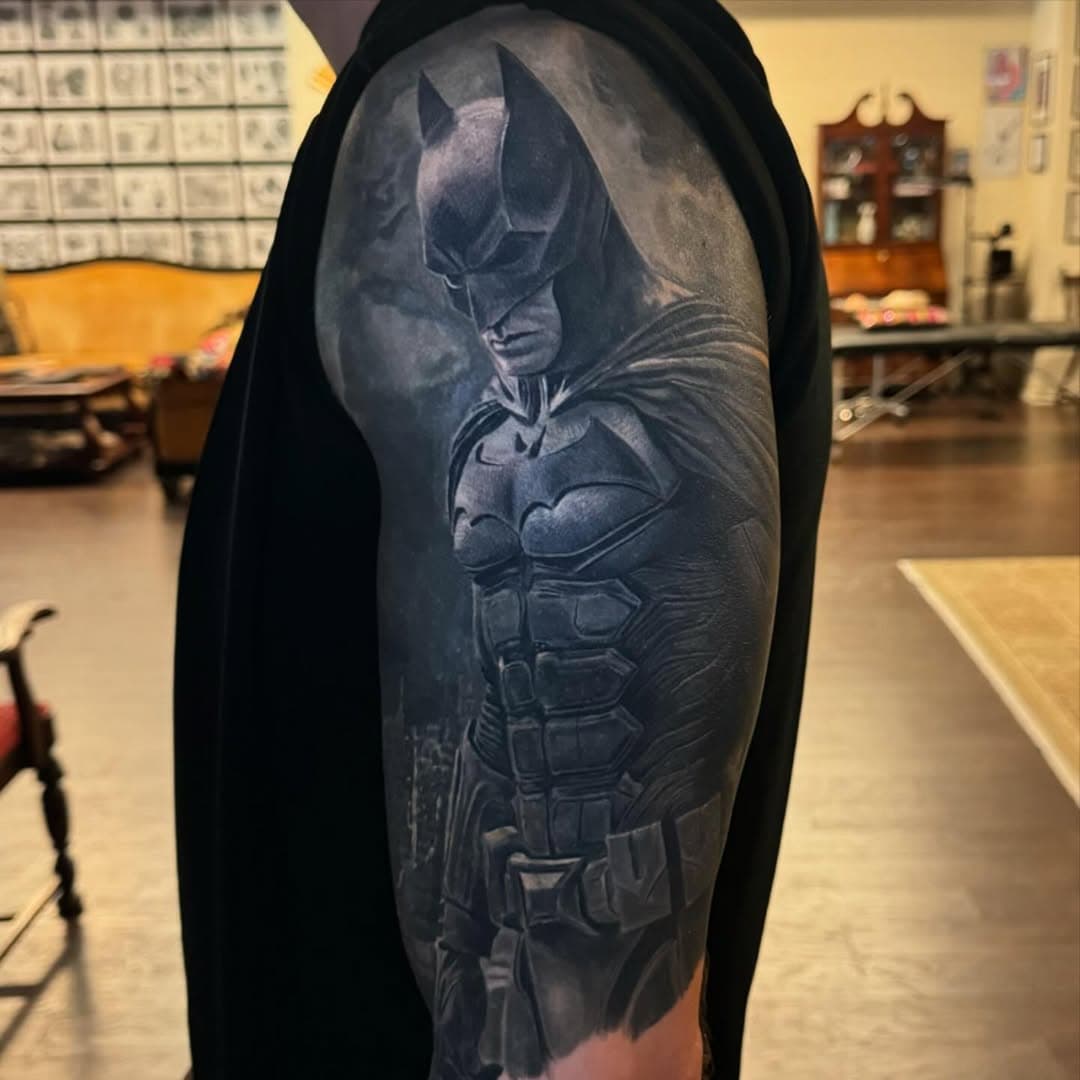 I got a chance to see this Batman coverup healed and suntanned 🫠🫠 but as most tattoos do end up in the sun and a lil tanned. I wanted to show yall a healed photo with a CPL lens under cold light, a CPL under neutral lighting (daylight lightbulb), outside in the shade no lens, outside in the shade with a CPL lens and natural light, and one in the sun no lens. As you can see alot of the opaque grays have browned a bit in the sun kinda taking away that cold feeling, but it was necessary to use them with greywash to fully saturate the cover up. We are gonna be doing a few touchups. Some blending, darkening and adding a lil batman signal to the sky. Overall very happy with this experiment and process of doing a cover up without any laser removal. I can still see portions of the previous tattoo showing through and that is almost always gonna happen with a cover up but I think the distraction is so drastic it goes pretty unnoticed. Hope you enjoy all these different photo versions and hope it helps further understand what is possible for a cover up as well as how things look healed and with normal day to day exposure. As well as how we as artists present our tattoos in the best way we can. For those of you who are unaware a CPL filter essentially blocks any glare. All photos are taken with an Iphone. In my opinion this tattoo will look even better after one more pass and during winter when its had time to lose the suntan and the inks are showing its truer hues and values. 

Made using @empireinks 
@kwadron
@cheyenne_tattooequipment 
@goodjudy.ca 

@devotiontattoomke @ghostlighttattooparlor