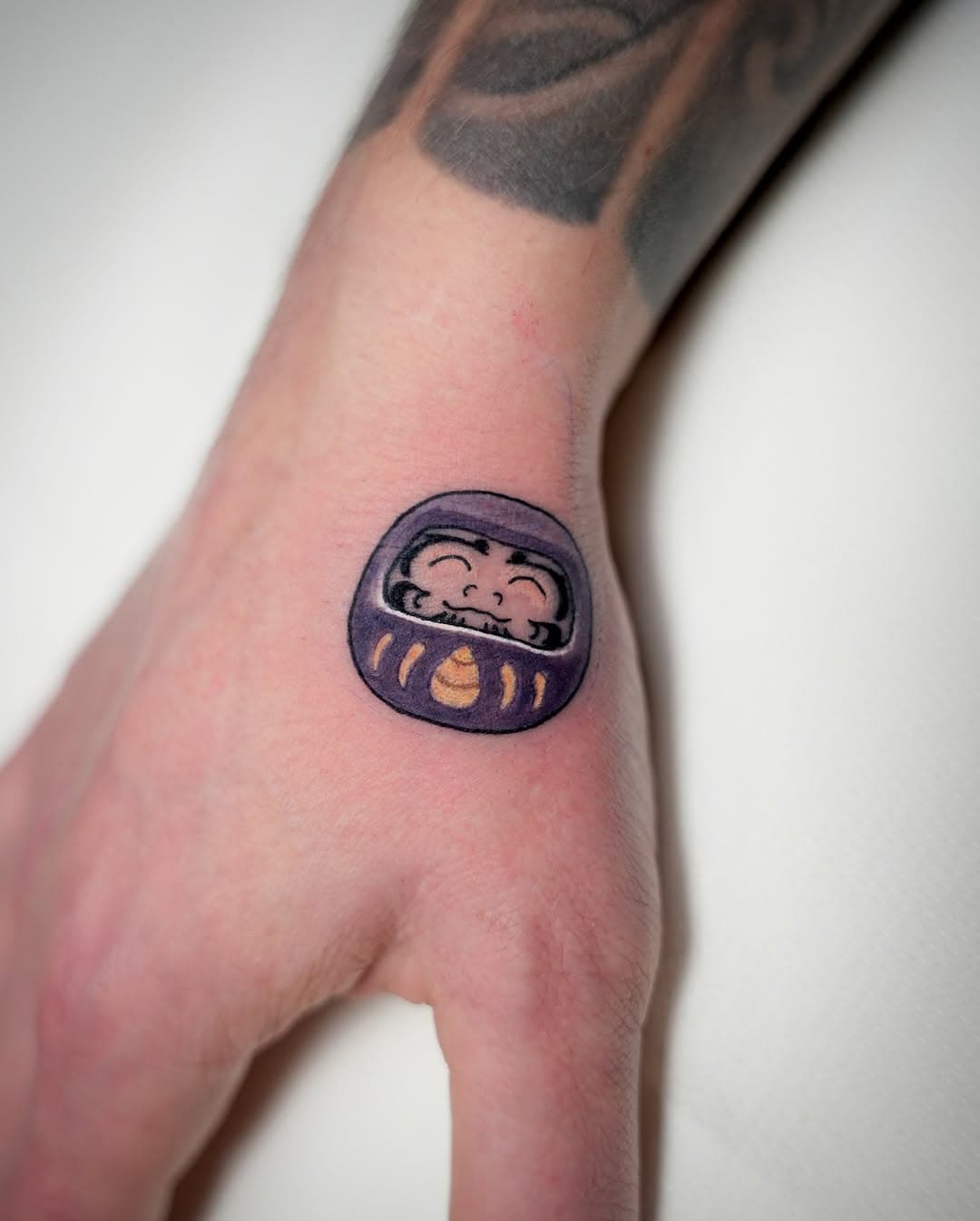 Happy little daruma doll, had so much fun with this one! 
May this purple fella bring you longevity and good health, O. 👏🏻
More small bangers like this one please 🫶🏻
•
Done @atelier.herbstgold_2.0 
•
•
#daruma #neotraditional #darumatattoo #neojapanese