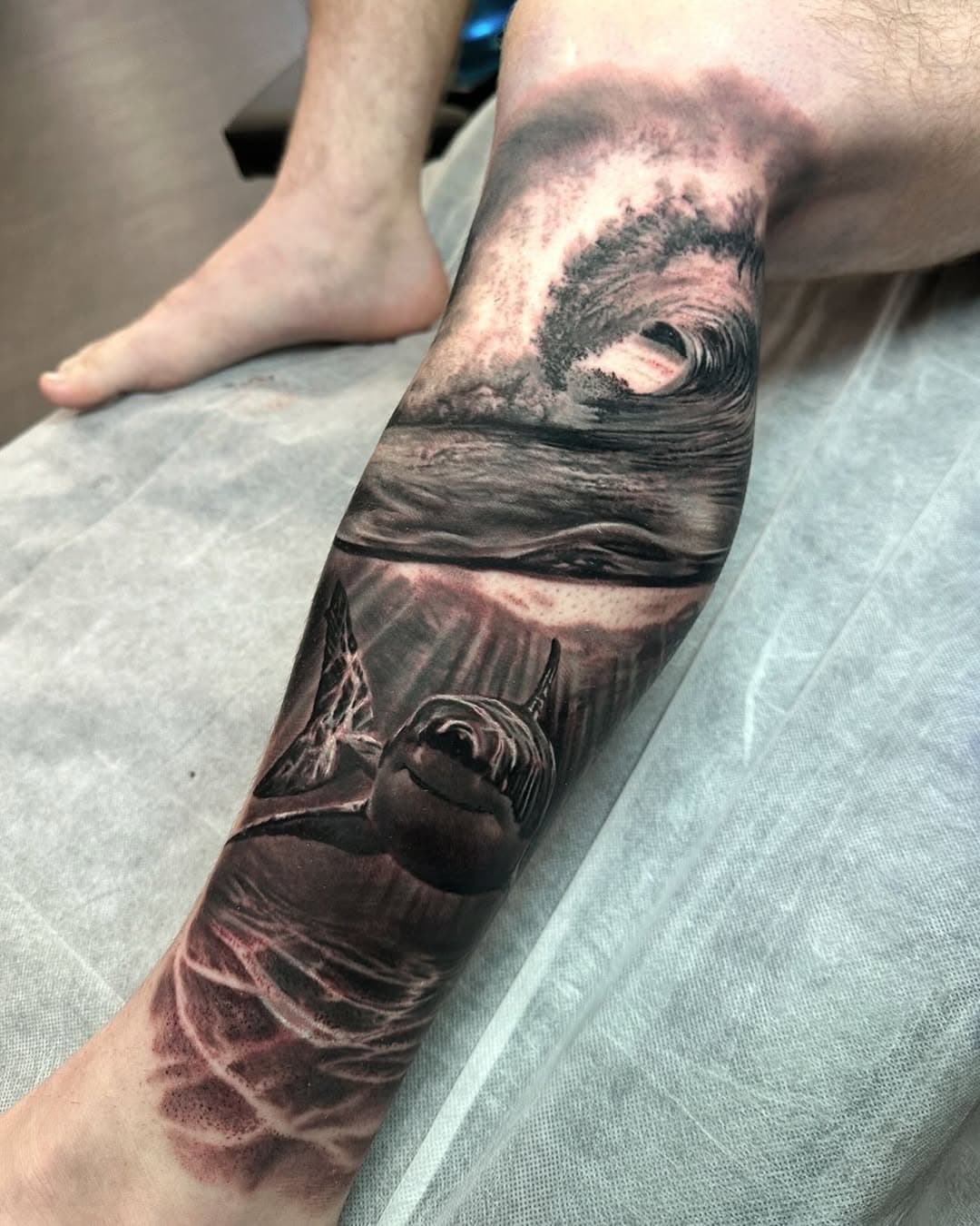 Shark in the shallows 🦈 🌊  I started this new leg sleeve just before I went in holidays. Thank you Ben for sitting so well especially after driving a crazy 14 hours! 🙌🏼🙏 

📍 @atlnts.studio

Bookings opening January 20th! 
For July onwards, via booking form on my website. This is the only place that I take bookings. Please beware of scammers impersonating me. If you have any concerns please DM me, my account is verified.

Cancellation list is also on my website 
Dylanwebertattoos.com

Sponsored by
@kwadron
@empireinks
@inkeeze
@inkjecta
@tattooarmour_australia 
@ghostlineapp

#sleevetattoo #portraittattoo #australianartist #kwadroncartridgesystem #kwadroncartridge #shark #sharktattoo #wave #wavetattoo #underwater #realism #blackandgreytattoo