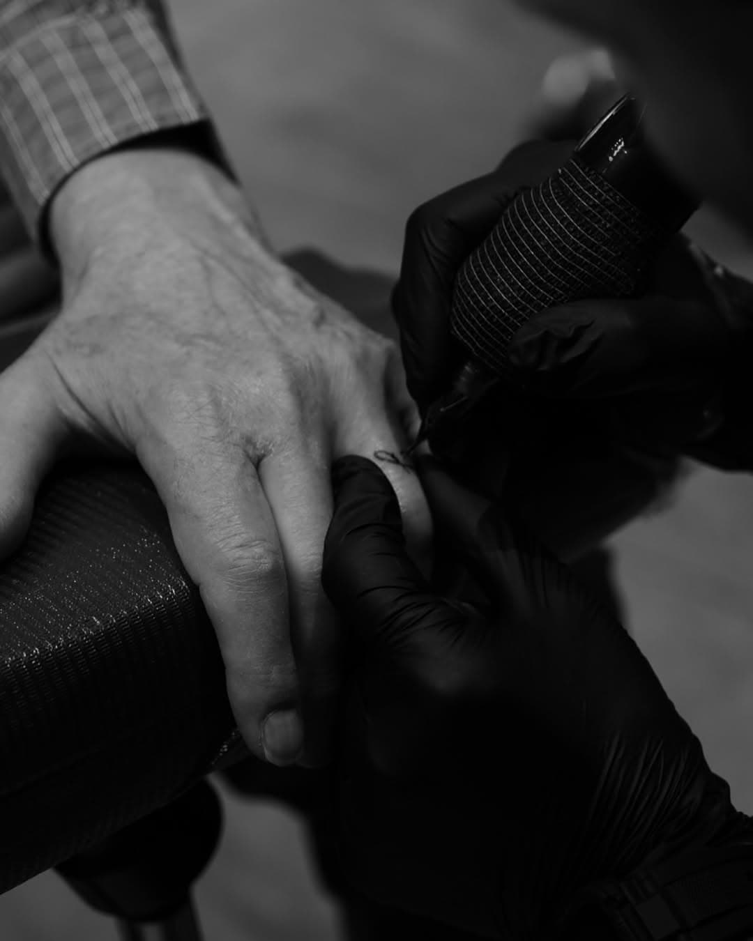 At eighty-one, he made his mark,
A symbol of love, a tiny spark.
Fifty-three years by her side,
Her first letter etched, a love so bright.

On his ring finger, so bold, so true,
A reminder of the years they’ve been through.
His first tattoo, a timeless song,
A love that has lasted, forever strong.