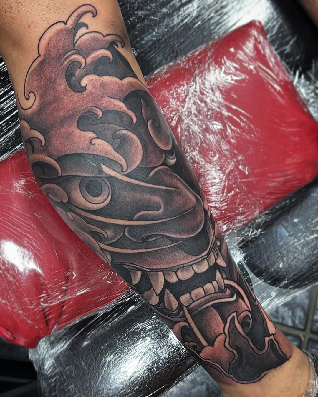 Lower leg tattoo Hannya mask on @ryan.paul96 . Inside of the leg nearly done too will show once it’s fully finished. Good day session done 🫡 #siamesetattoofamily #blackandgreytattoo #hannyatattoo #waves #oriental #tattoo